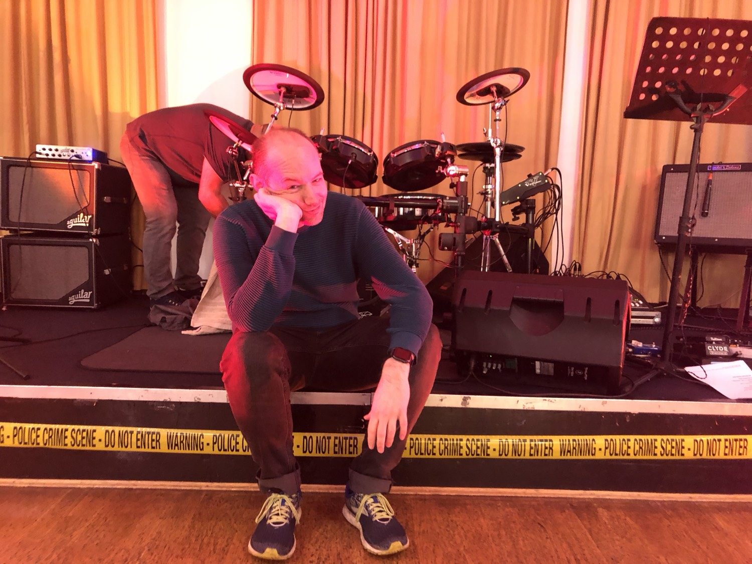 Terry Blyth sitting at the front of the stage between sets