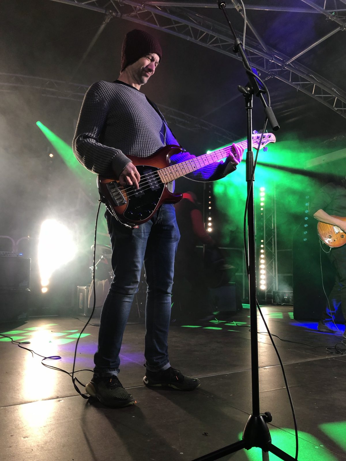 Terry Blyth playing bass under green stage lights